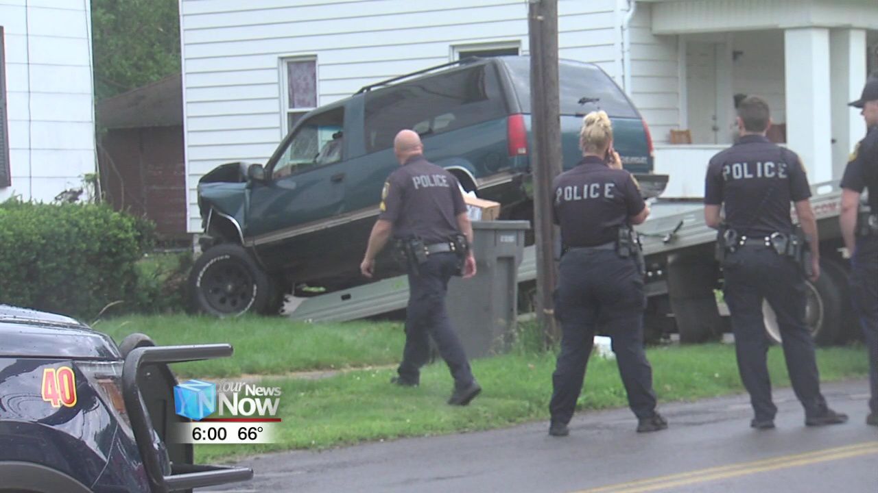 Police investigating car vs. house crash.jpg